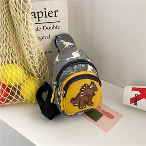 Detail of kids dinosaur chest bag featuring 3D triceratops patch and yellow zip pocket