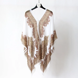 Detailed view of lightweight white chiffon shawl with gold paisley print and pearl button