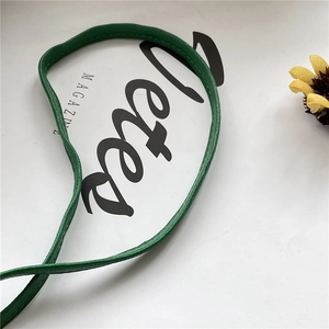 Detailed view of green strawberry bag handle with high-quality lychee leather texture