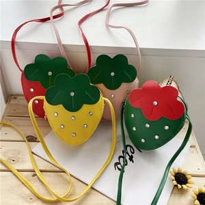 Detailed top view of strawberry-shaped crossbody bags in four vibrant colors with rhinestones