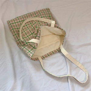 Detail view of the gingham tote bag interior featuring an open pocket and soft fabric texture