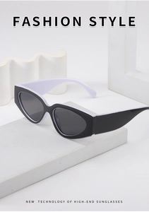 Close-up of cat-eye sunglasses in black and white finish on a minimalist display stand