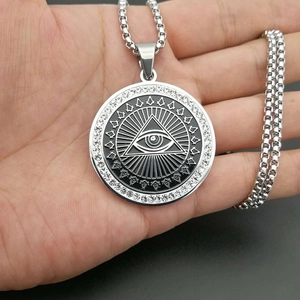 Iced out silver hip hop necklace with gold plated Eye of Providence pendant on hand