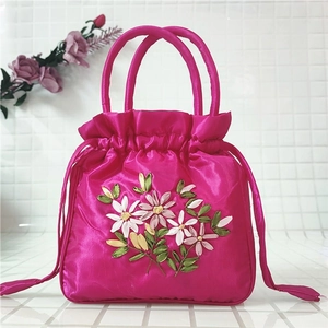 Detail view of rose red satin drawstring bag featuring intricate ribbon floral embroidery