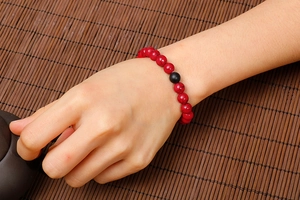 Elastic beaded bracelet with red turquoise beads and a black matte accent stone