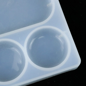 Detailed macro view of a translucent white silicone mold with round cavities for DIY crafts