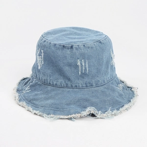 Detail view of washed denim bucket hat with distressed edges and frayed brim texture