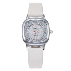 Detailed close-up of a silver square watch case with diamond bezel and white leather strap