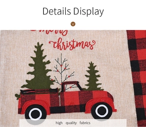Close-up of linen Christmas placemat with red truck and Merry Christmas text