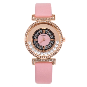 Detail of rose gold barrel watch with pink leather strap and crystal diamond bezel