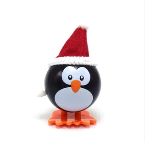 Schattig kerstpinguïn opwindspeelgoed met rode kerstmuts en zwart lichaam op wit