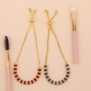Detail of adjustable 18K gold-plated bracelets with colorful rectangular cubic zirconia stones