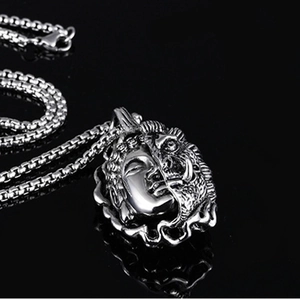 Detail of silver double-sided pendant with Buddha and demon faces on box chain