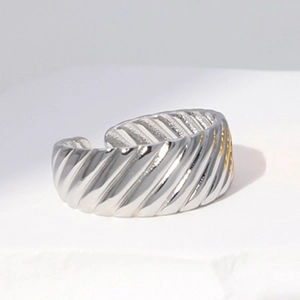 Macro shot of wide silver stainless steel ring featuring unique diagonal wave textures