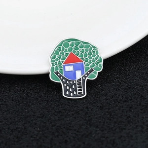 Macro shot of a colorful enamel treehouse brooch on a white ceramic plate