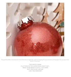 Close-up of a 6cm red glitter Christmas ball ornament with silver cap on festive background