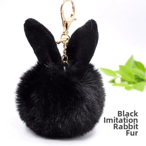 Close-up of black faux rex rabbit fur pompom keychain with gold lobster clasp