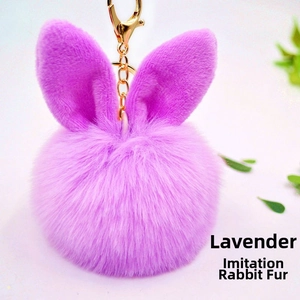 Detail of lavender faux rabbit fur pompom keychain with bunny ears and gold hardware