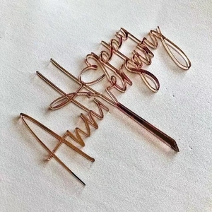 Rose gold acrylic Happy Anniversary cake topper on a light textured background