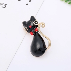 Detail of a cute black enamel cat brooch with golden edges and a sparkling red rhinestone bow