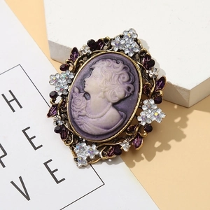 Vintage Victorian cameo brooch with purple female silhouette and gold filigree frame