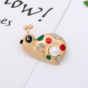 Macro shot of cute snail brooch with white imitation pearl and colorful enamel details