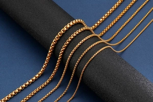Polished gold stainless steel box chains in multiple thicknesses on display pedestals