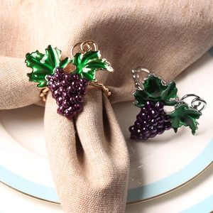 Grape napkin rings with purple beads on golden base shown in an elegant table setting