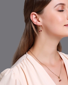 Gros plan d'un ensemble collier et boucles d'oreilles nœud avec cristaux rouges