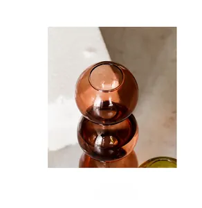 Gros plan du rebord lisse d'un vase en verre ambré avec reflet sur miroir poli