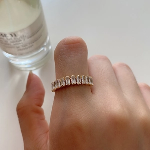 Gold plated 925 silver ring with rectangular zircons worn on thumb for a stylish look