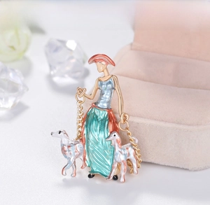 Detailed view of elegant enamel lady brooch with two dogs on a light jewelry display
