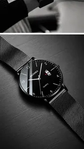 Detail of ultra-thin quartz watch with black Milanese mesh strap and date window