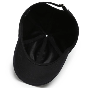 Internal view of black cotton baseball cap showing 6-panel design and adjustable gold buckle
