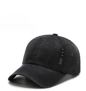 Detail of washed black cotton baseball cap showing metallic studs and DST lettering