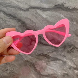 Gros plan sur des lunettes de soleil roses en forme de cœur pour enfants en plastique
