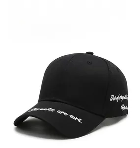 Dettaglio del ricamo bianco su un cappellino da baseball in cotone nero stile streetwear