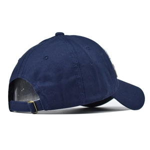 Detail of navy blue cotton baseball cap featuring an adjustable strap with metal buckle