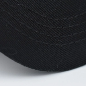 Macro view of black twill cotton baseball cap brim with four rows of reinforced stitching