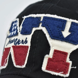 Distressed black cotton baseball cap featuring vintage NY embroidered patch with raw edges