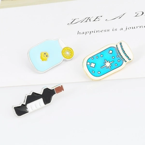 Detailed view of three cute enamel pins including a star jar and a lemon bottle