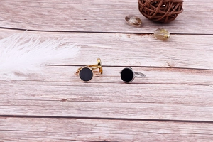 Macro shot of gold silver and rose gold rings with black inlay on wood background