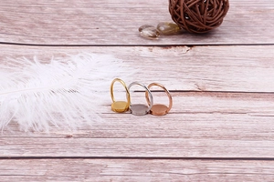 DIY jewelry base rings in gold, silver, and rose gold finishes on wood background