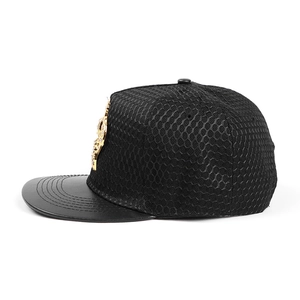 Side view detail of black hip hop cap with gold metal crown badge and mesh back
