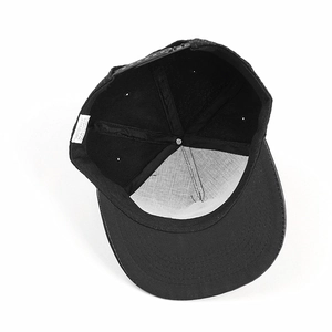 Detail view of the black hip hop cap's interior seams, inner lining and 100% acrylic label