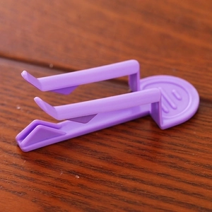 Purple plastic trash bag clips set on a wooden table for non-slip bin liner securing