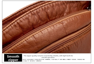 Détail des fermetures éclair en métal et du cuir marron texturé sur le sac à bandoulière