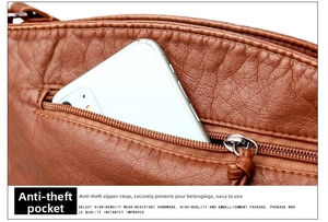 Detailed view of the anti-theft back zipper pocket on brown pebbled leather shoulder bag