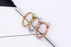 Détail de trois bagues minimalistes en or, argent et or rose serties de zircons brillants