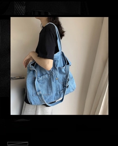 Detail shot of vintage light blue denim tote bag showing wide straps and outer pockets